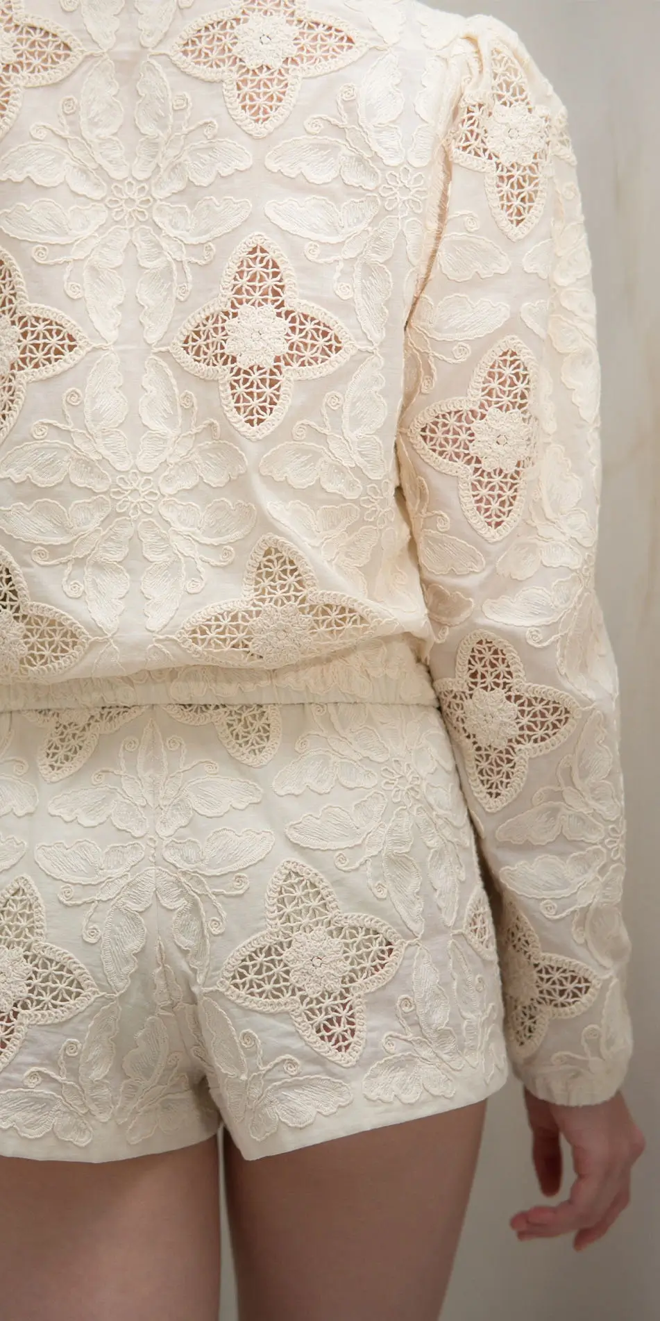 Round neck embroidered cotton jacket in cream back close up waist